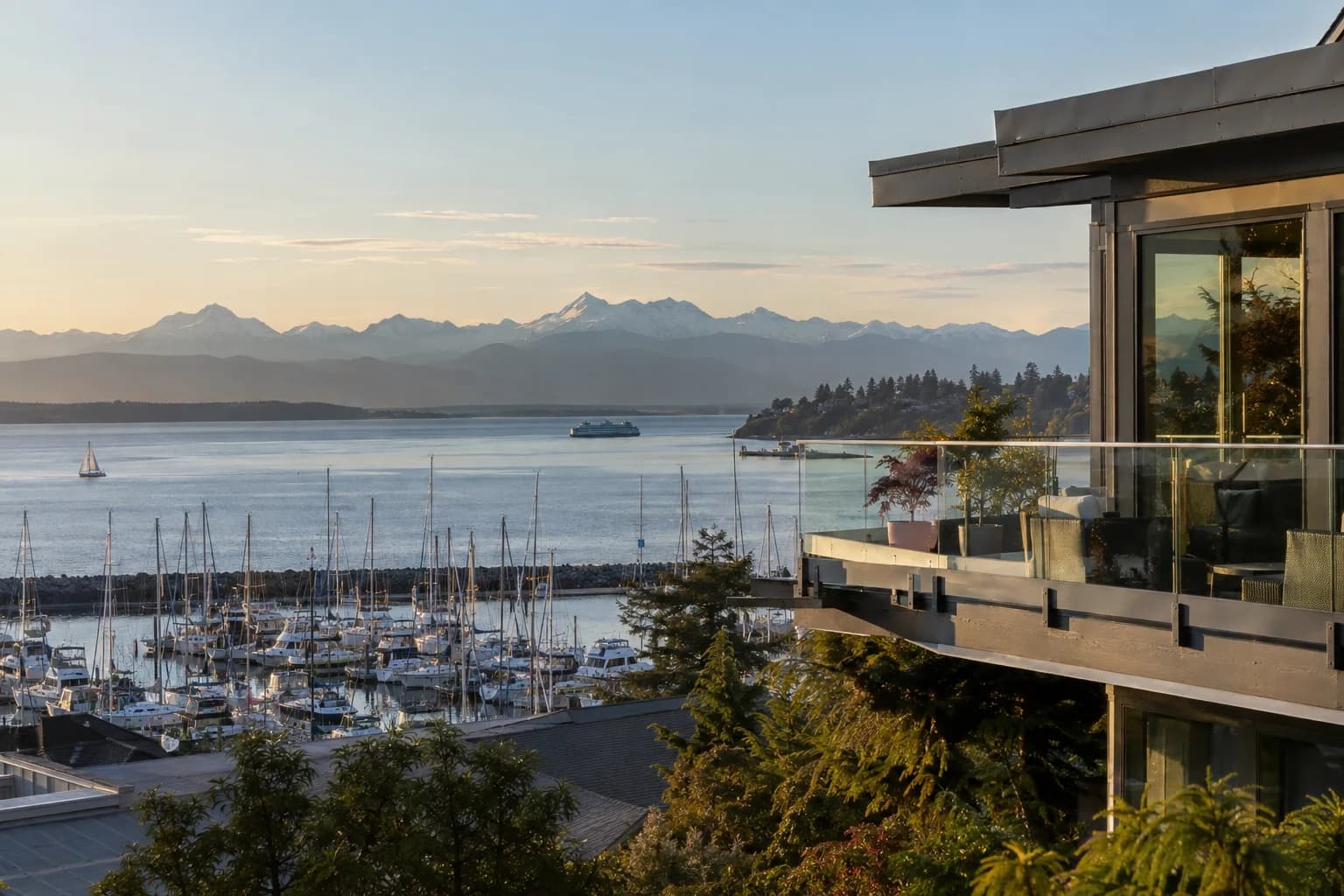 Hillside home with a glass-railed balcony over the marina in Des Moines, Washington, with the Des Moines marina with masts, Puget Sound and the Olympic Mountains