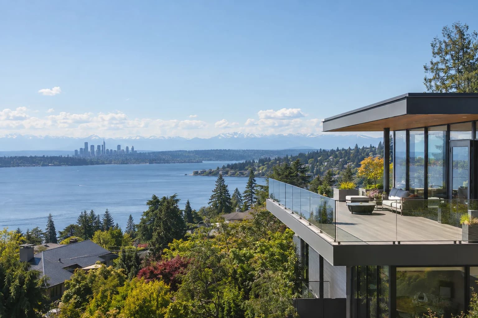 Northwest contemporary hillside home with a glass terrace in Eastside, Washington, with a hillside between Bellevue and Kirkland with Lake Washington, the Seattle skyline and the Olympic Mountains