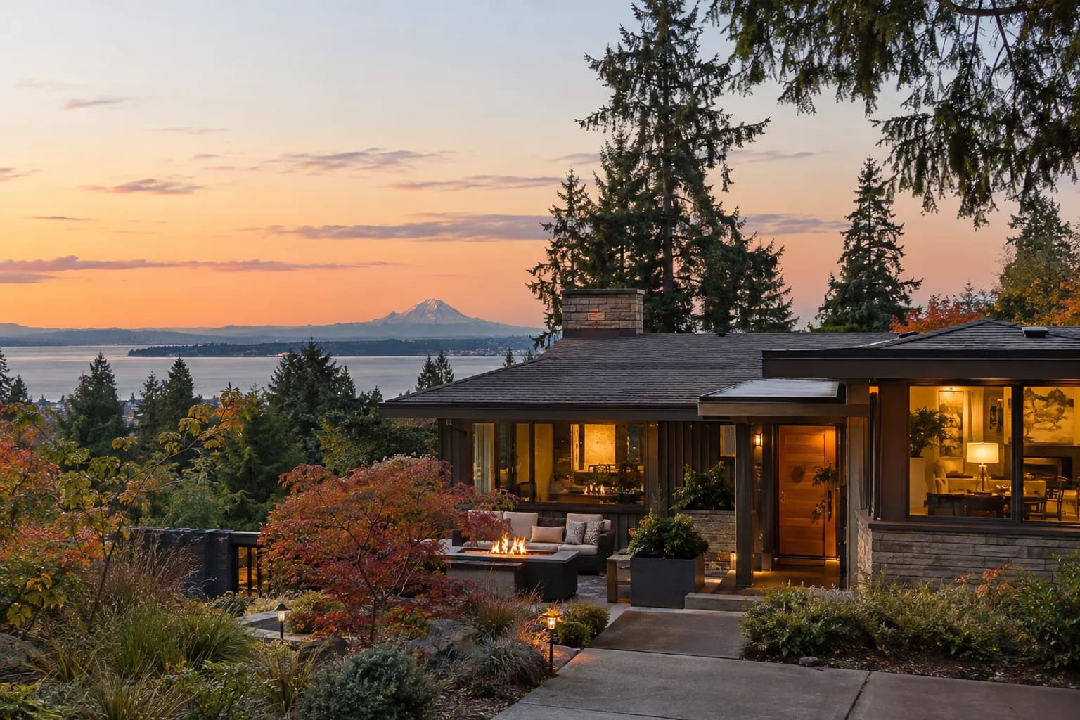 Beautifully updated 1960s home with a fire-table patio in Lynnwood, Washington, with a garden lot with tall firs and string lights at dusk
