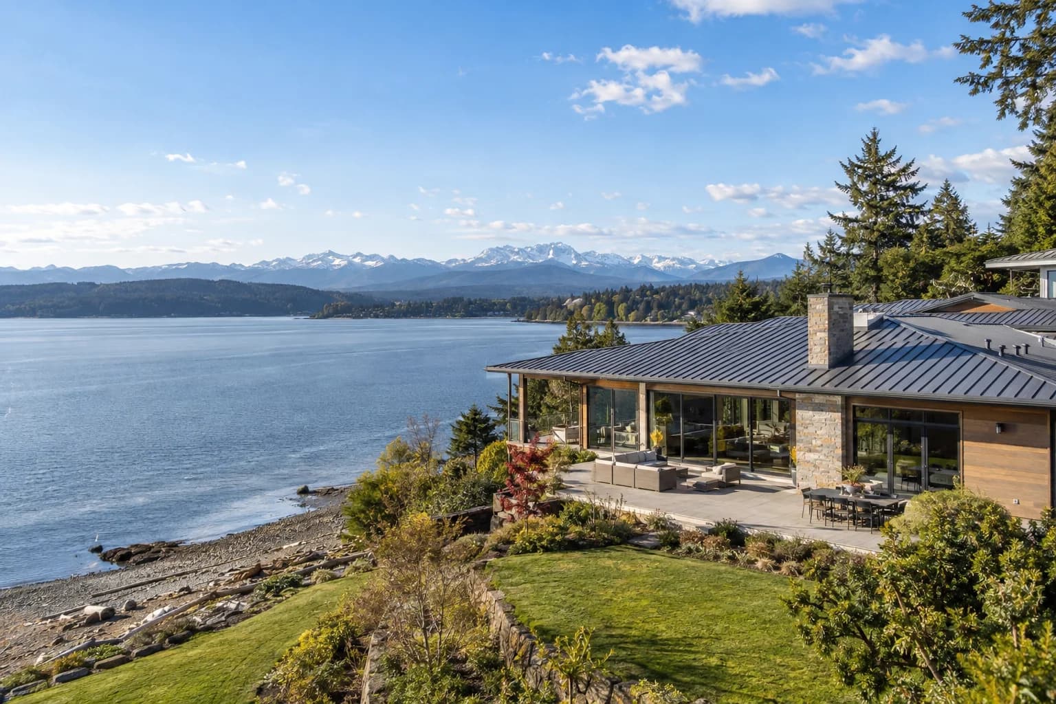 Newer waterfront home with a lawn to the beach in Silverdale, Washington, with Dyes Inlet with the Olympic Mountains across the water