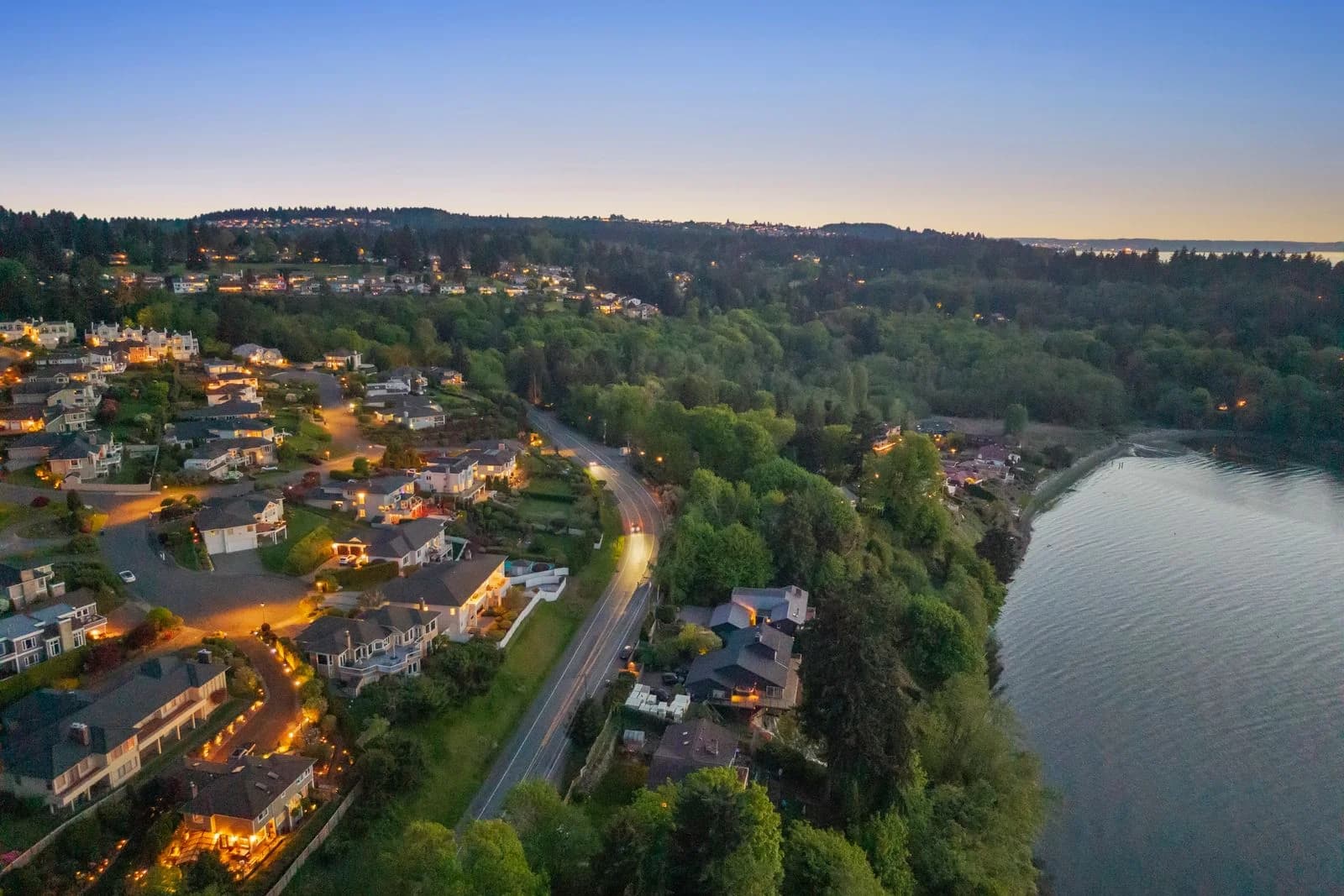 Wide twilight aerial view showing neighborhood and Puget Sound