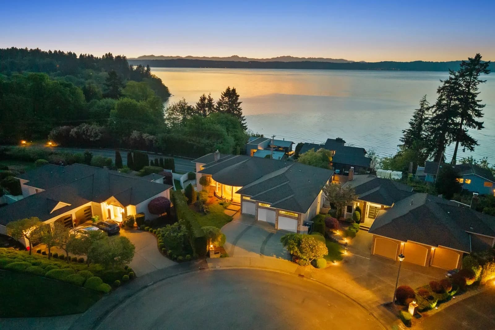 Close twilight aerial view of home exterior and pool