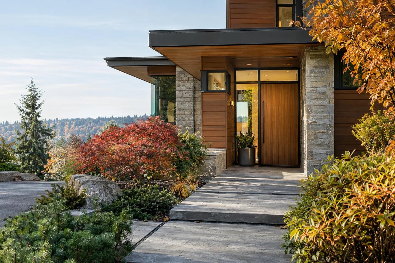 Crisp autumn driveway approach to a modern Northwest home, stone path and cedar siding in Bellevue — RexMont Real Estate