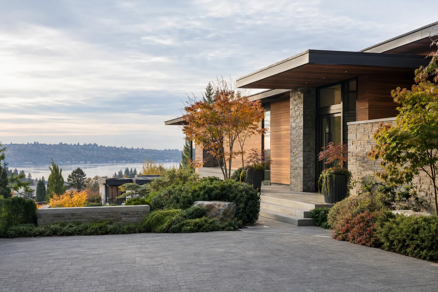 Crisp autumn driveway approach to a modern Northwest home, stone path and cedar siding in Clyde Hill — RexMont Real Estate