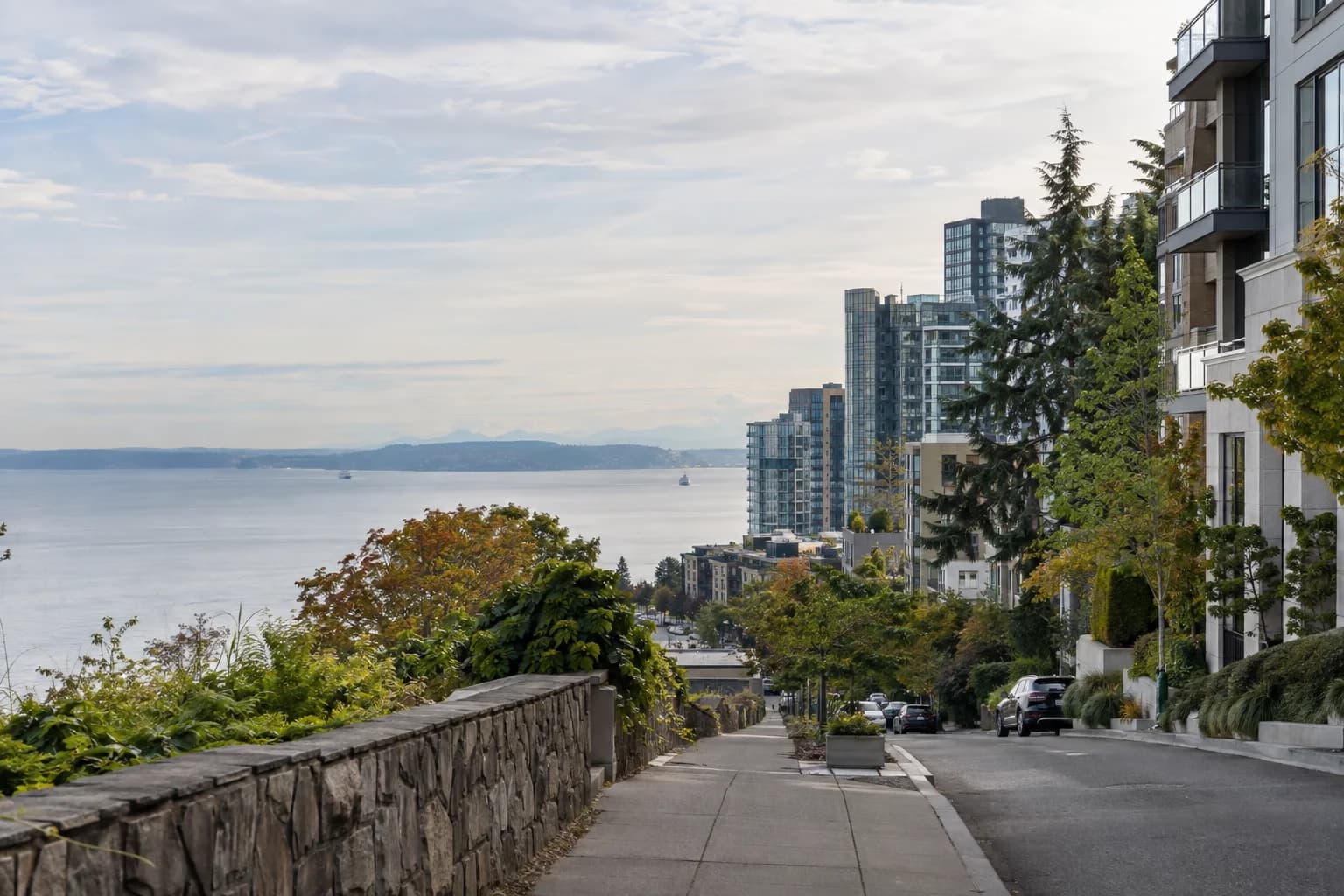 Urban high-rise street approach framed by trees and stone in Seattle — RexMont Real Estate