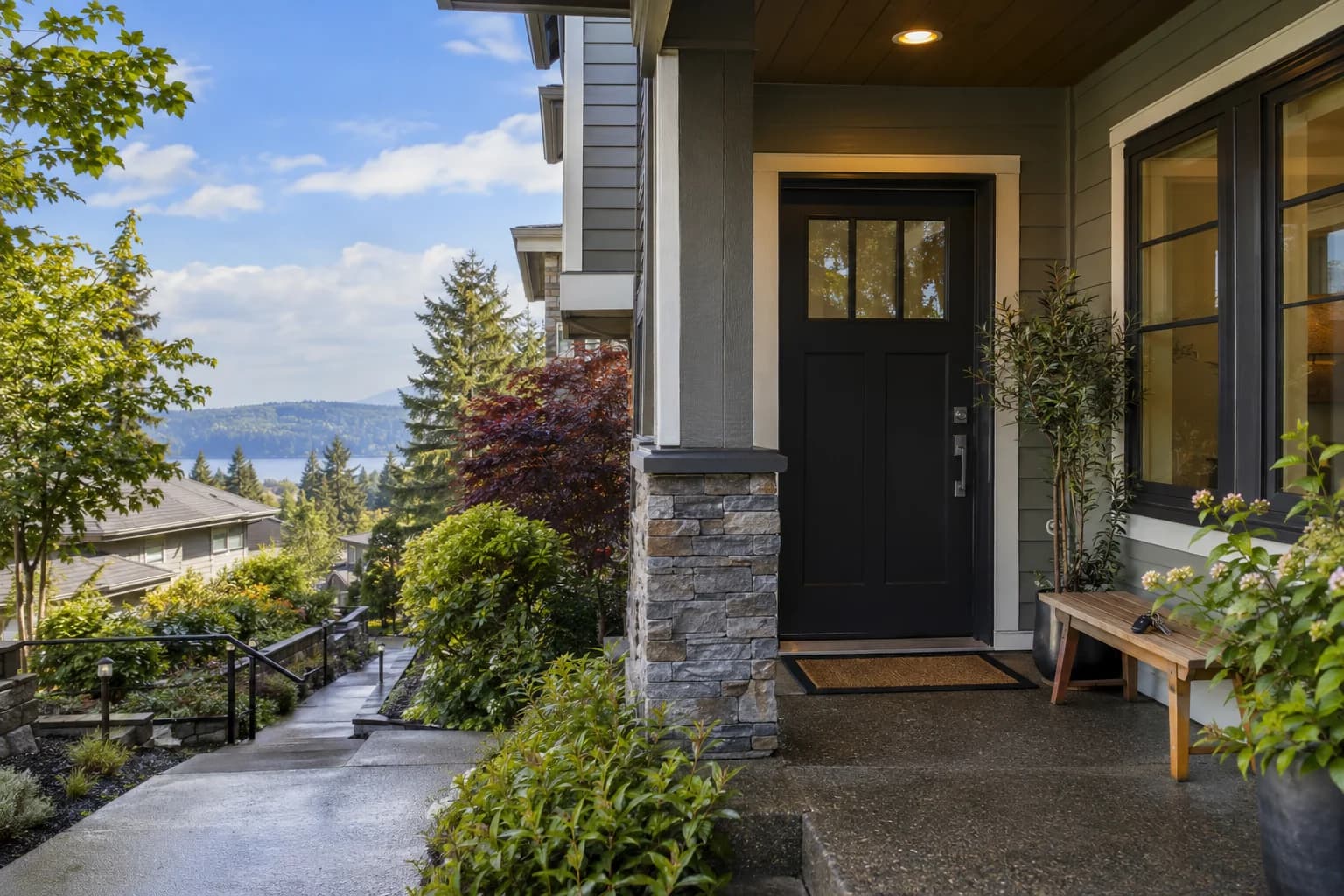 Rainy front porch of a well-kept rental townhome, keys on a small wood bench in Sammamish — RexMont Real Estate
