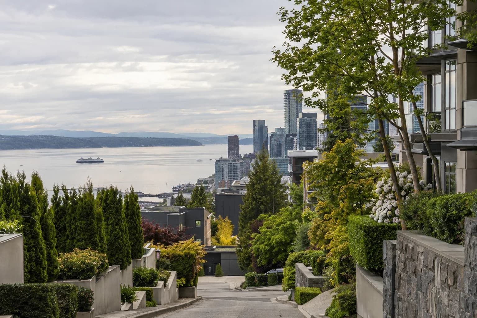 Urban high-rise street approach framed by trees and stone in Seattle — RexMont Real Estate